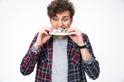 Young casual man biting money over gray background-2